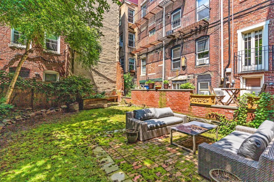 A courtyard outside of the home with trees and seating areas.