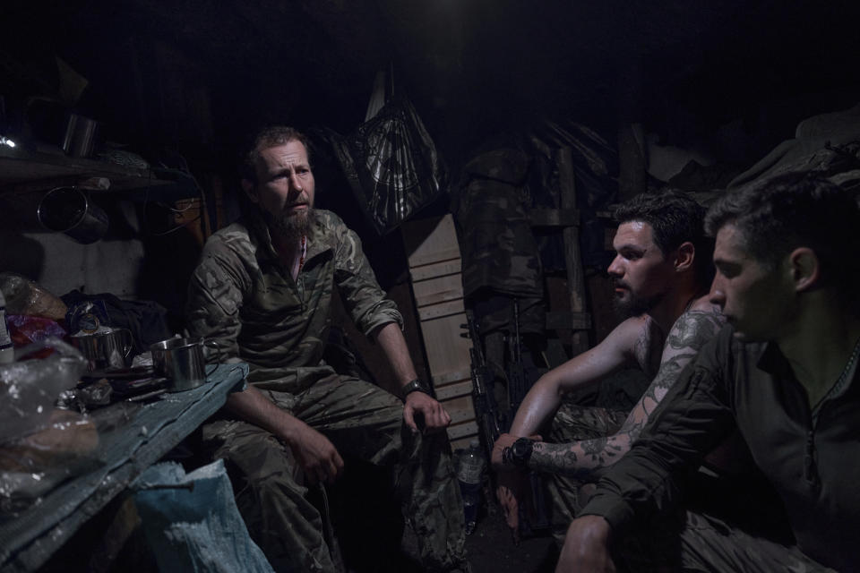 FILE - Ukrainian soldiers sit in a recently captured Russian trench on the frontline near Bakhmut, Donetsk region, Ukraine, Tuesday, July 4 2023. Ukrainian forces are making steady progress along the northern and southern flanks of Bakhmut, in a semi-encirclement of the wrecked city that Russian forces have been occupying since May. (AP photo/Libkos, File)