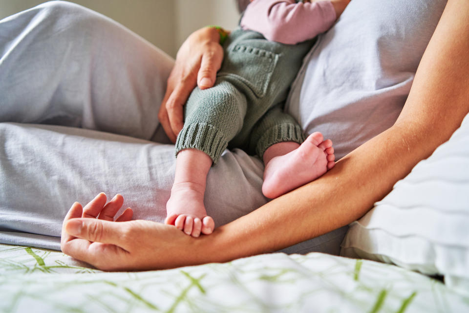 Woman breastfeeding baby in bed