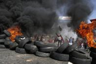 Members of Brazil's Homeless Workers' Movement (MTST), who are living at the "People's World Cup Camp" which houses some 2,800 families of the movement in the district of Itaquera near Sao Paulo's World Cup stadium, Arena de Sao Paulo, block a road during a protest against the 2014 World Cup in Sao Paulo, May 15, 2014. Cities across Brazil braced for demonstrations on Thursday, as disparate protest movements seek to criticize spending on the upcoming World Cup soccer tournament and revive a call for better public services that swept the country last June. Though most demonstrations are expected to gain steam later in the day, protestors in Sao Paulo, the country's biggest city, by early morning had blocked a major thoroughfare with burning tires and disrupted commutes elsewhere. REUTERS/Nacho Doce (BRAZIL - Tags: SPORT SOCCER WORLD CUP CIVIL UNREST)