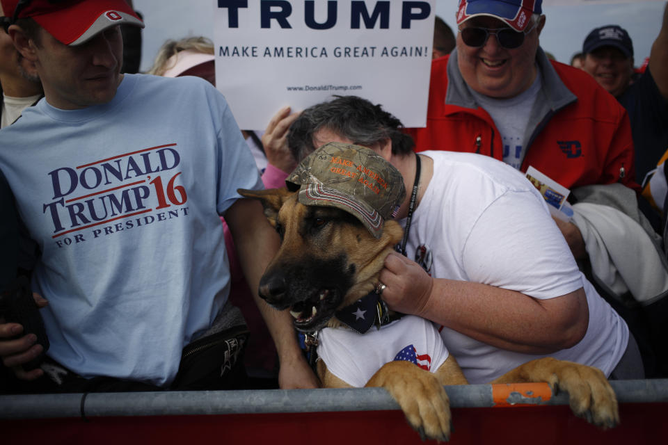 People and a German shepherd wait for the start of a campaign event for Donald Trump in Dayton, Ohio, on March 12, 2016.