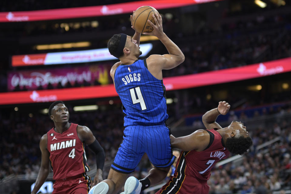 Orlando Magic guard Jalen Suggs (4) is called for an offensive foul while going up to shoot while defended by Miami Heat guard Kyle Lowry (7) as Heat guard Victor Oladipo (4), left, watches during the first half of an NBA basketball game, Saturday, March 11, 2023, in Orlando, Fla. (AP Photo/Phelan M. Ebenhack)