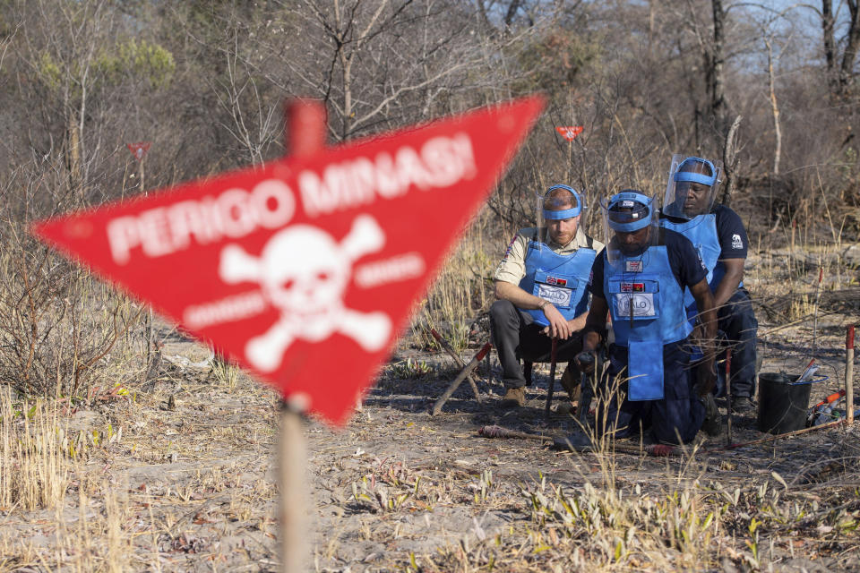 Britain's Prince Harry watches a controlled explosion in a partially cleared minefield in Dirico, Angola Friday Sept. 27, 2019, during a visit to see the work of landmine clearance charity the Halo Trust, on day five of the royal tour of Africa. Prince Harry is following in the footsteps of his late mother, Princess Diana, whose walk through an active mine field in Angola years ago helped to lead to a global ban on the deadly weapons. (Dominic Lipinski/Pool via AP)