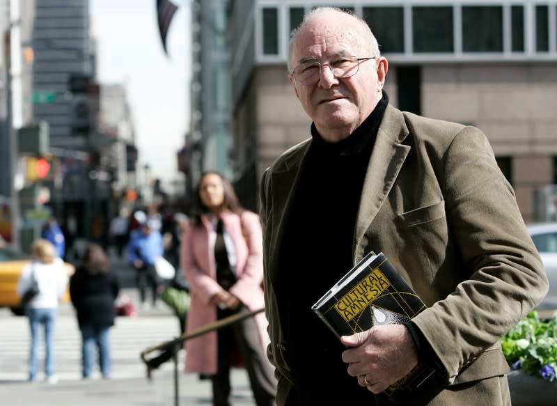 FILE PHOTO: Author Clive James poses with copy of his latest book "Cultural Amnesia" in New York