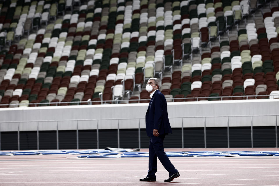 IOC President Thomas Bach visits the National Stadium, the main venue for the 2020 Olympic and Paralympic Games postponed until July 2021 due to the coronavirus pandemic, in Tokyo Tuesday, Nov. 17, 2020. Bach said during this week's trip to Tokyo that he is “encouraging” all Olympic “participants” and fans to be vaccinated - if one becomes available - if they are going to attend next year's Tokyo Olympics. (Behrouz Mehri/Pool Photo via AP)