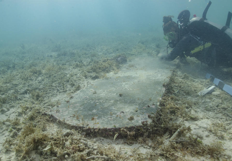 This image courtesy of the National Park Service shows University of Miami graduate student Devon Fogarty examining the headstone of John Greer, which was found underwater by archeologists during a survey at Dry Tortugas National Park in August 2022, in Florida. Archeologists have found the remains of a 19th century quarantine hospital and cemetery on a submerged island in Florida's Dry Tortugas National Park, according to park officials Monday, May 1, 2023. (C. Sproul/National Park Service via AP)