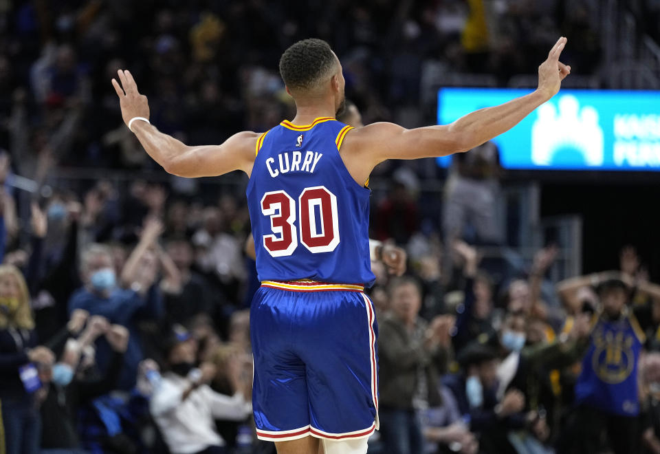 Stephen Curry, facing away from the camera, celebrates after making a 3-pointer. 