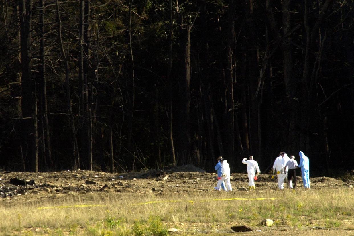 Investigators head into the debris field at the site of a commercial plane crash near Shanksville, Pennsylvania, September 11, 2001. The crash is one of four planes that were hijacked as part of a deadly and destructive terrorist plot. In the worst attack on American soil since Pearl Harbor, three hijacked planes slammed into the Pentagon and New York's landmark World Trade Center on Tuesday, demolishing the two 110-story towers that symbolize U.S. financial might.