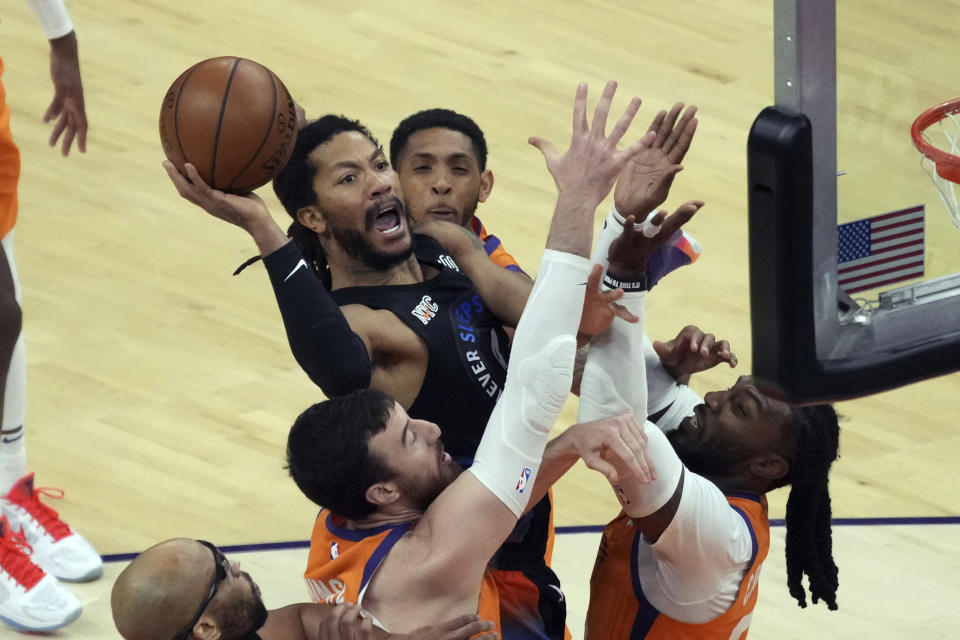 New York Knicks guard Derrick Rose shoots between Phoenix Suns forward Mikal Bridges, top, forward Frank Kaminsky, bottom left, and forward Jae Crowder, right, during the second half of an NBA basketball game Friday, May 7, 2021, in Phoenix. (AP Photo/Rick Scuteri)