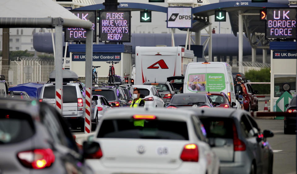 People queue in line to check-in for the cross channel ferry in Calais, France, Friday Aug.14, 2020. British holiday makers in France were mulling whether to return home early Friday to avoid having to self-isolate for 14 days following the U.K. government's decision to reimpose quarantine restrictions on France amid a recent pick-up in coronavirus infections. (AP Photo/Olivier Matthys)