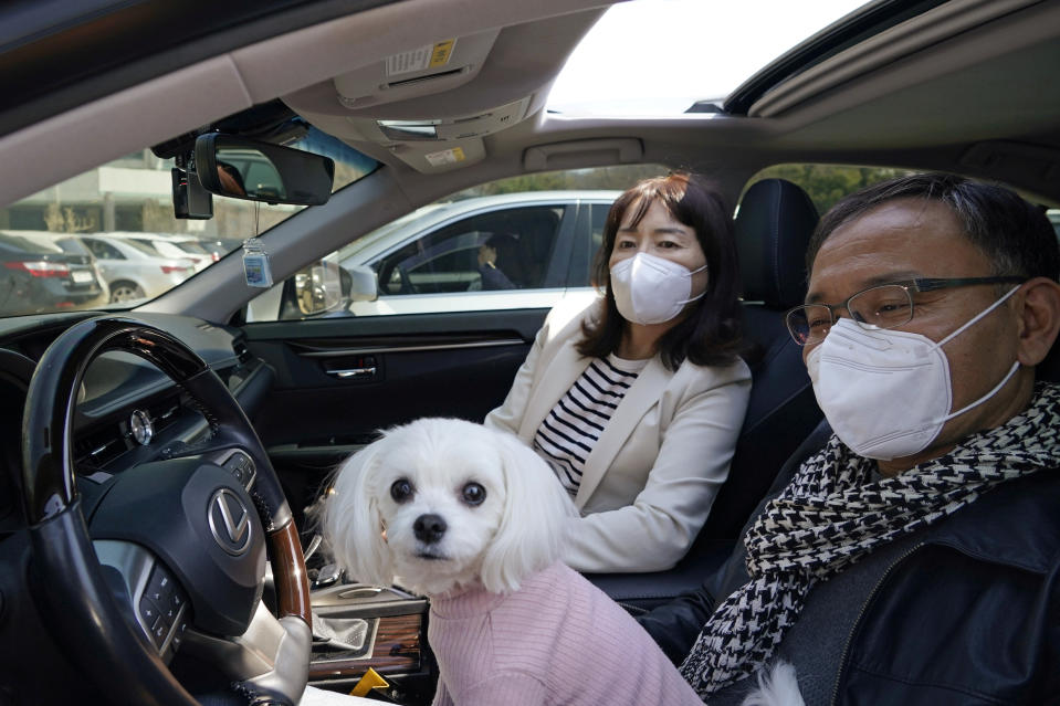 South Korean Christians wearing protective face masks sit with a dog during a drive-in worship service following the outbreak of the coronavirus disease (COVID-19) in Seoul, South Korea, April 5, 2020. REUTERS/Kim Hong-Ji