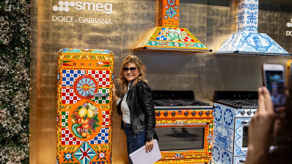 A woman poses next to a Dolce & Gabbana for Smeg limited edition refrigerator at the SMEG display stand during the Salone Internazionale del Mobile at Fiera di Rho on April 17, 2018 in Milan, Italy. - Emanuele Cremaschi/Getty Images