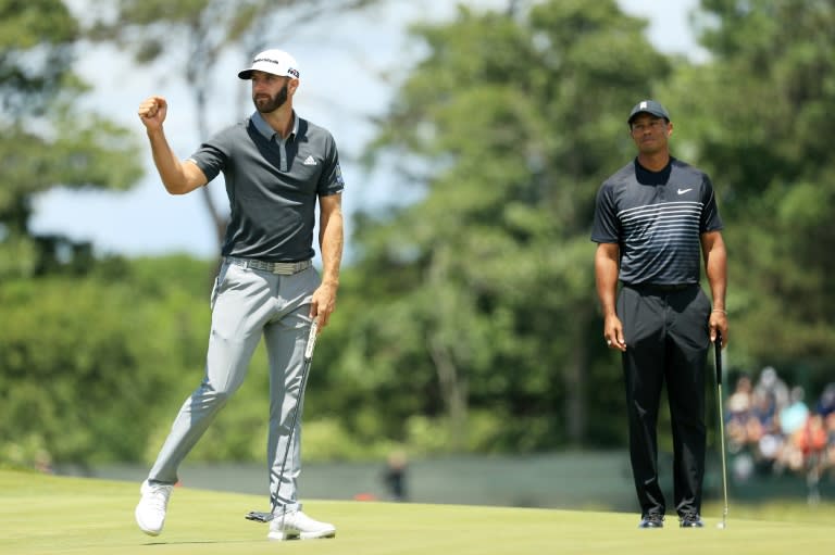 Dustin Johnson celebrates making a birdie on the seventh hole as Tiger Woods looks on during the second round of the US Open