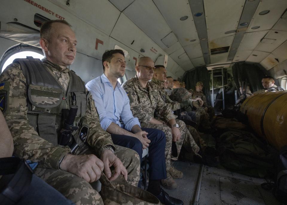 Ukrainian President Volodymyr Zelenskiy, second left, sits inside a military helicopter while visiting the war-hit Luhansk region, eastern Ukraine, Monday, May 27, 2019. (Ukrainian Presidential Press Office via AP)