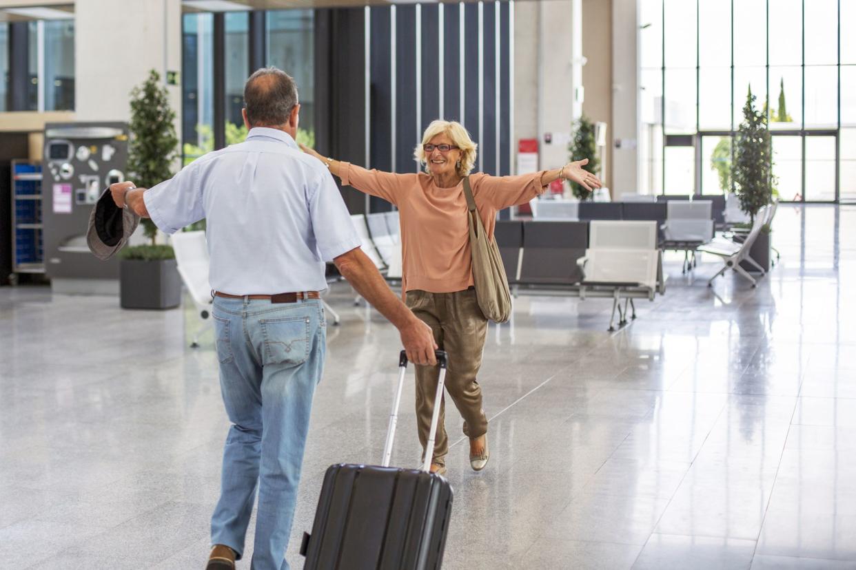 woman welcoming man at airport gate