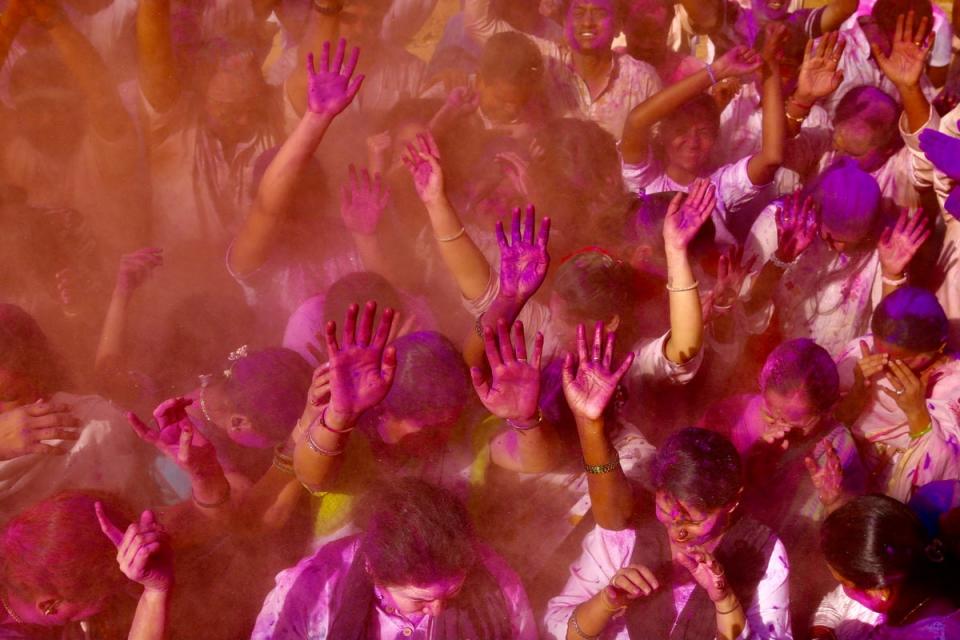 People covered with colored powder take part in the Holi festival celebrations in Bangalore (EPA)