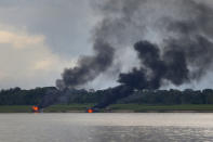 Two of the more than 60 dredging barges that were set on fire by officers of the Brazilian Institute of the Environment and Renewable Natural Resources, IBAMA, burn on the shore during an operation to try to contain illegal gold mining on the Madeira river, a tributary of the Amazon river in Borba, Amazonas state, Brazil, Sunday, Nov. 28, 2021. Hundreds of barges belonging to illegal miners had converged on the river during a gold rush in the Brazilian Amazon prompting IBAMA authorities to start burning them. (AP Photo/Edmar Barros)