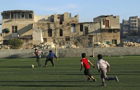 Boys play with a soccer ball in the al-Klaseh neighbourhood of Aleppo in this November 8, 2014 file photo. REUTERS/Hosam Katan/Files