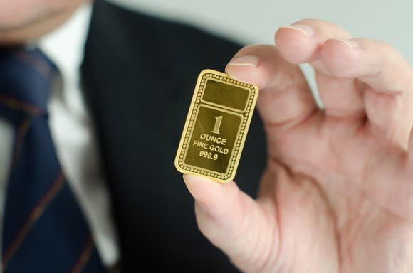 A man holding a gold ingot