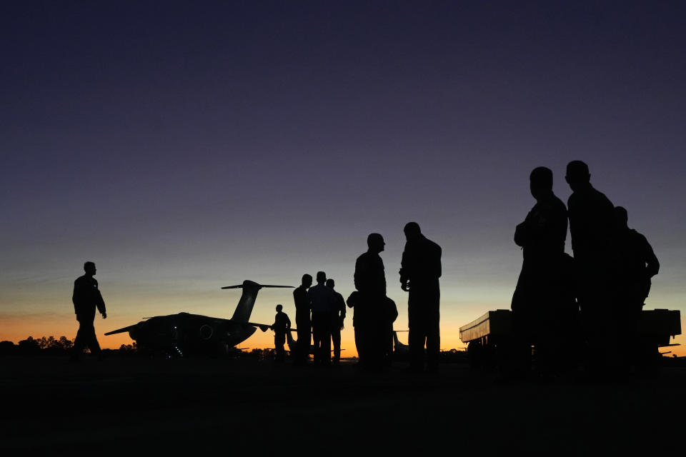 Military move through the yard preparing donations for humanitarian aid for victims and people who lost their homes from floods caused by heavy rains in the cities of the Rio Grande do Sul state, at the Air Base in Brasilia, Brazil, Saturday, May 11, 2024. (AP Photo/Eraldo Peres)