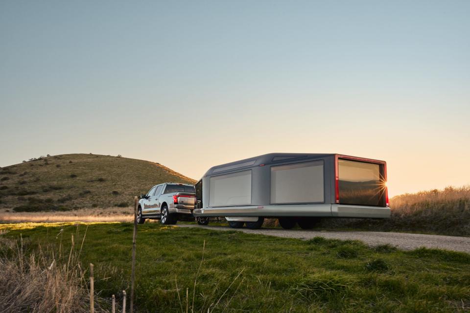 Lightship's electric L1 travel trailer being towed outside in nature.