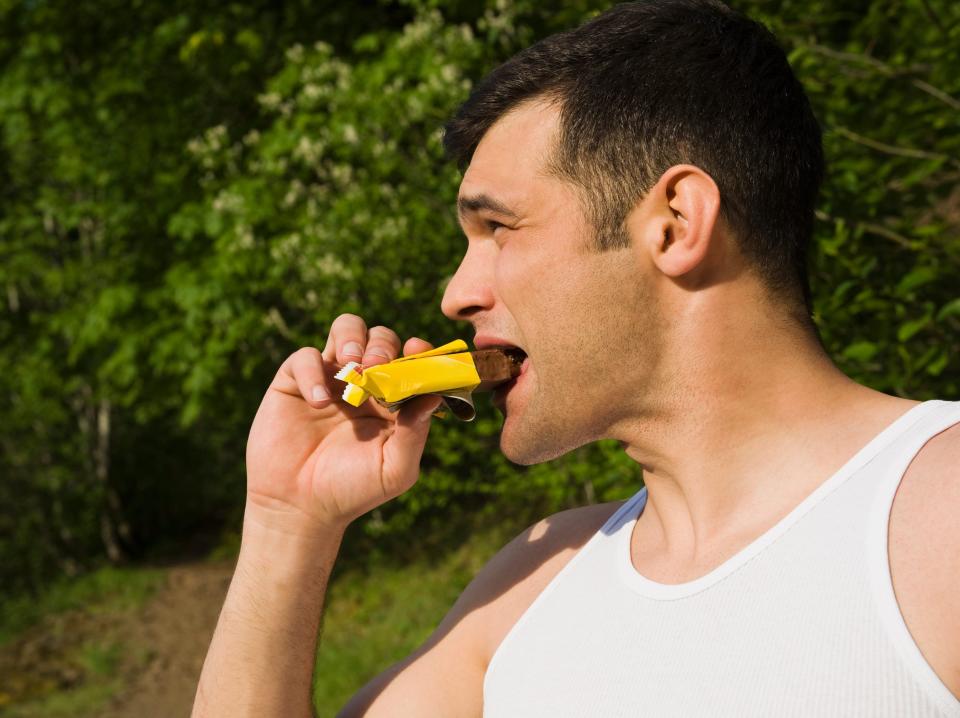 man eating energy bar