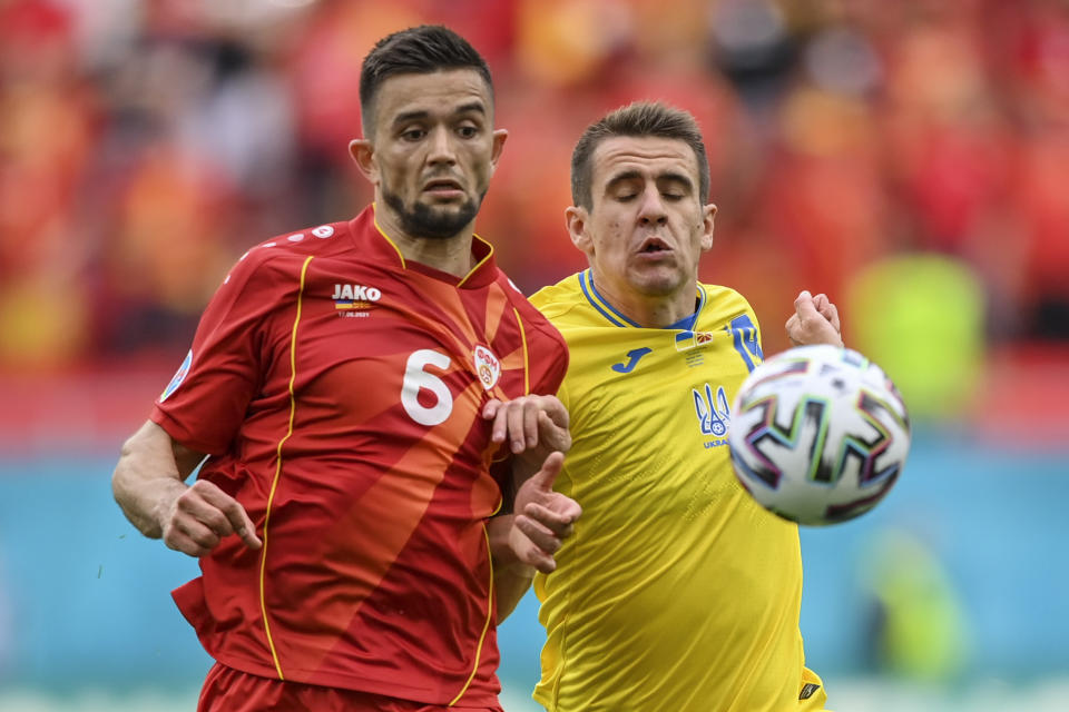 North Macedonia's Visar Musliu, left, duels for the ball with Ukraine's Artem Besyedin during the Euro 2020 soccer championship group C match between Ukraine and North Macedonia at the National Arena stadium in Bucharest, Romania, Thursday, June 17, 2021. (Justin Setterfield, Pool via AP)