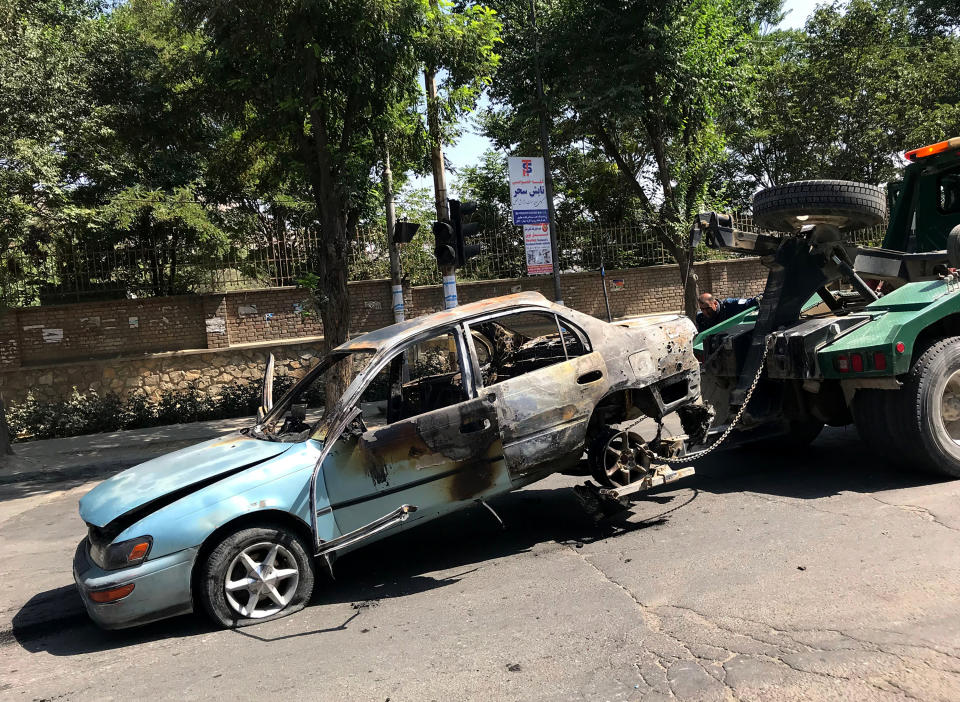 A damaged car is towed away from the site of an explosion in Kabul, Afghanistan, Friday, July 19, 2019. A powerful bomb exploded outside the gates of Kabul University in the Afghan capital on Friday, according to police and health officials. (AP Photo)