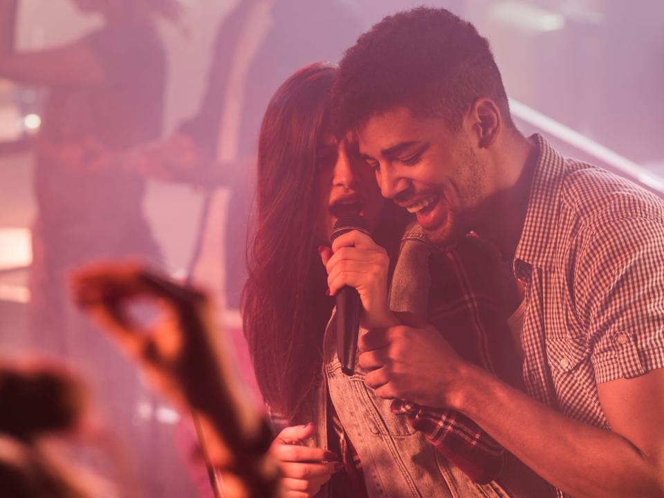 A couple singing together in a bar.