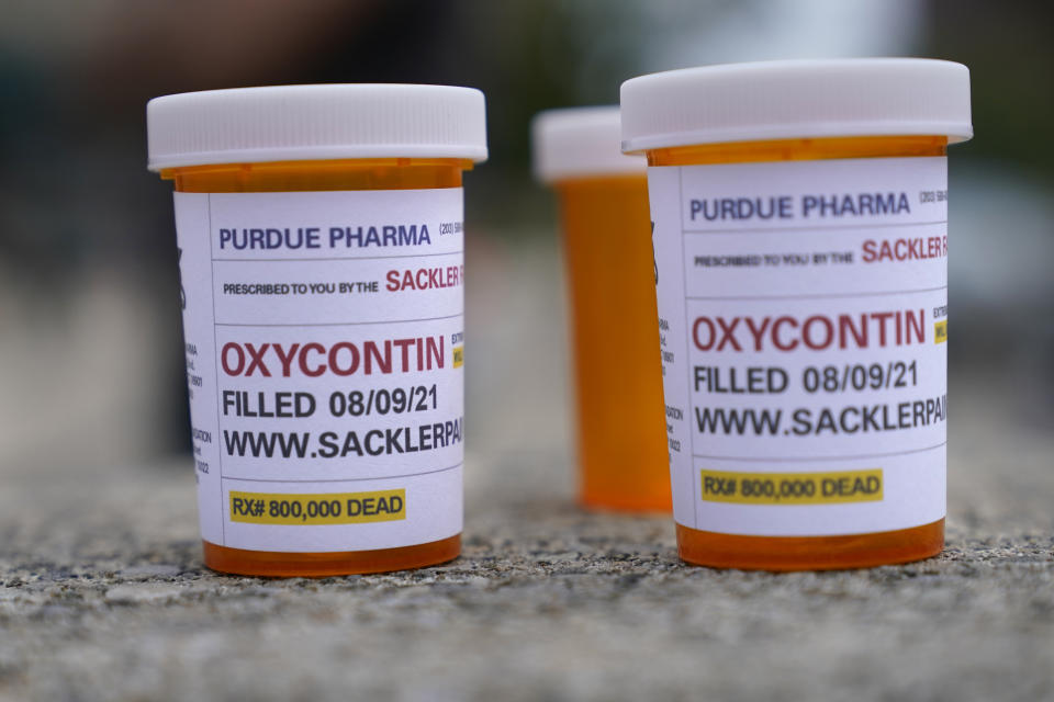 Fake pill bottles with messages about Purdue Pharma are displayed during a protest outside the courthouse where the bankruptcy of the company is taking place in White Plains, N.Y., Monday, Aug. 9, 2021. Purdue Pharma's quest to settle thousands of lawsuits over the toll of OxyContin is entering its final phase with the grudging acceptance of most of those with claims against the company. (AP Photo/Seth Wenig)