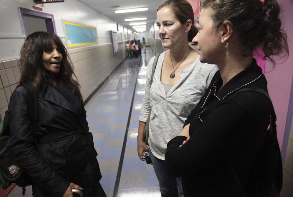 April Gayles, left, Jen Zunt, center, Lea Mansour, chat as they leave the PTA office at P.S. 75 on Friday, Sept. 28, 2012 in New York. Neighborhood residents are in turmoil over an adult shelter near the school on 95th Street, saying they were blindsided by the suddenness of the shelter's opening. Zunt, a mother of a fifth grader at the school, said she is concerned about safety and the mental state of residents at the shelter. (AP Photo/Bebeto Matthews)