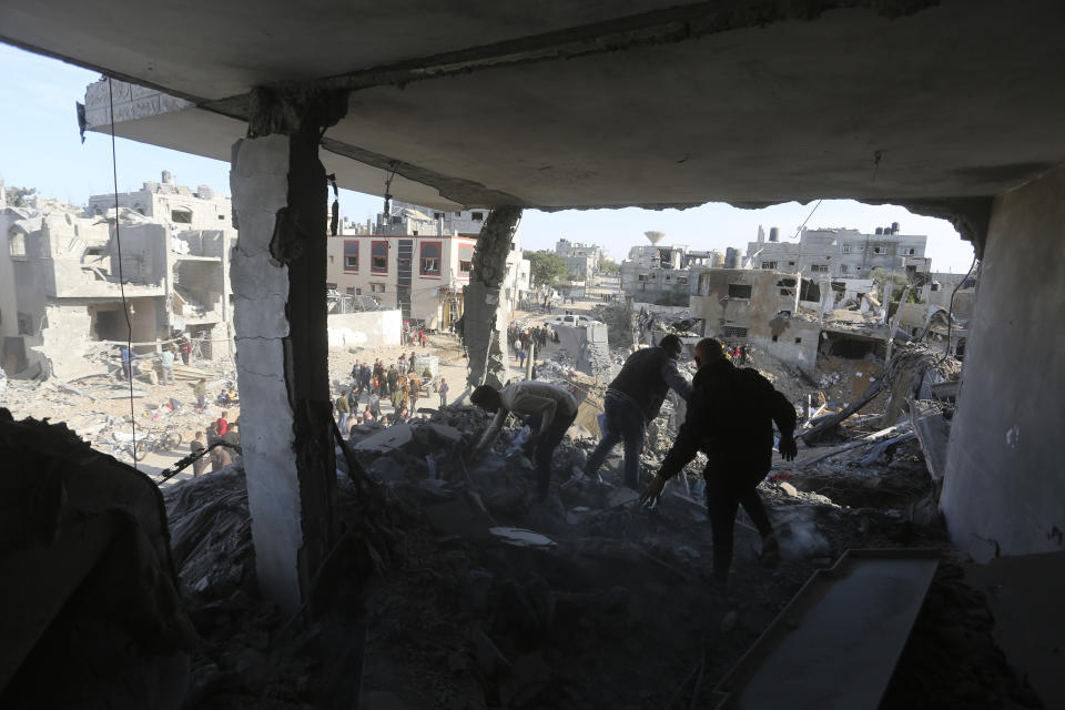 Palestinians look at the destruction by the Israeli bombardment of the Gaza Strip in Rafah, Monday, Dec. 4, 2023. (AP Photo/Hatem Ali)