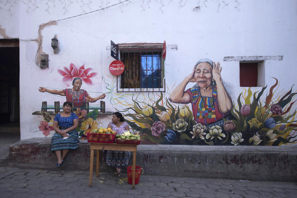 Maya Tz'utujil women sell fruit in San Juan La Laguna, Guatemala, Tuesday, March 12, 2019. An English tourist whose body was found near a Guatemala highland lake popular with travelers died of hemorrhaging resulting from a traumatic brain injury, according to an autopsy report completed Tuesday. (AP Photo/Santiago Billy)