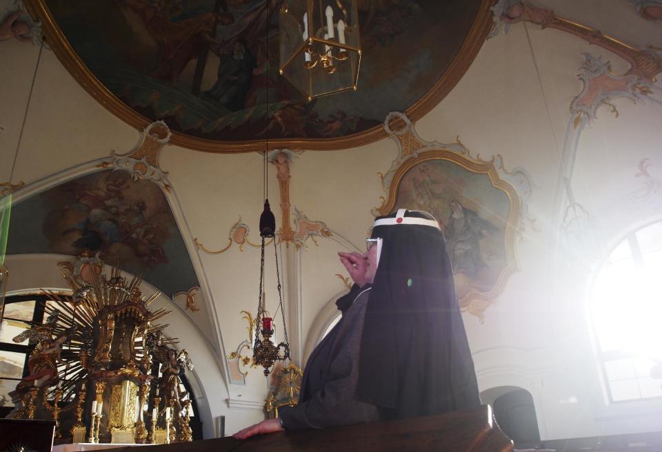 CORRECTS DETAILS ABOUT THE ABBEY In this Dec. 6, 2016 photo Sister Apollonia the chapel of the abbey in Altomuenster, Germany. The impending dissolution of a 15th-century monastery in Bavaria is pitting scholars against Catholic church officials. The library in Altomuenster Abbey, accessible only to the monastery’s nuns for more than five centuries, contains precious illuminated manuscripts and other treasures. Scholars worry the “holy grail” for Bridgettine Order research could be damaged, broken up or sold off before it can be catalogued and studied. (AP Photo/David Rising)