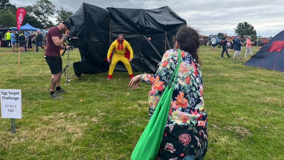 a woman throwing an egg at a human target