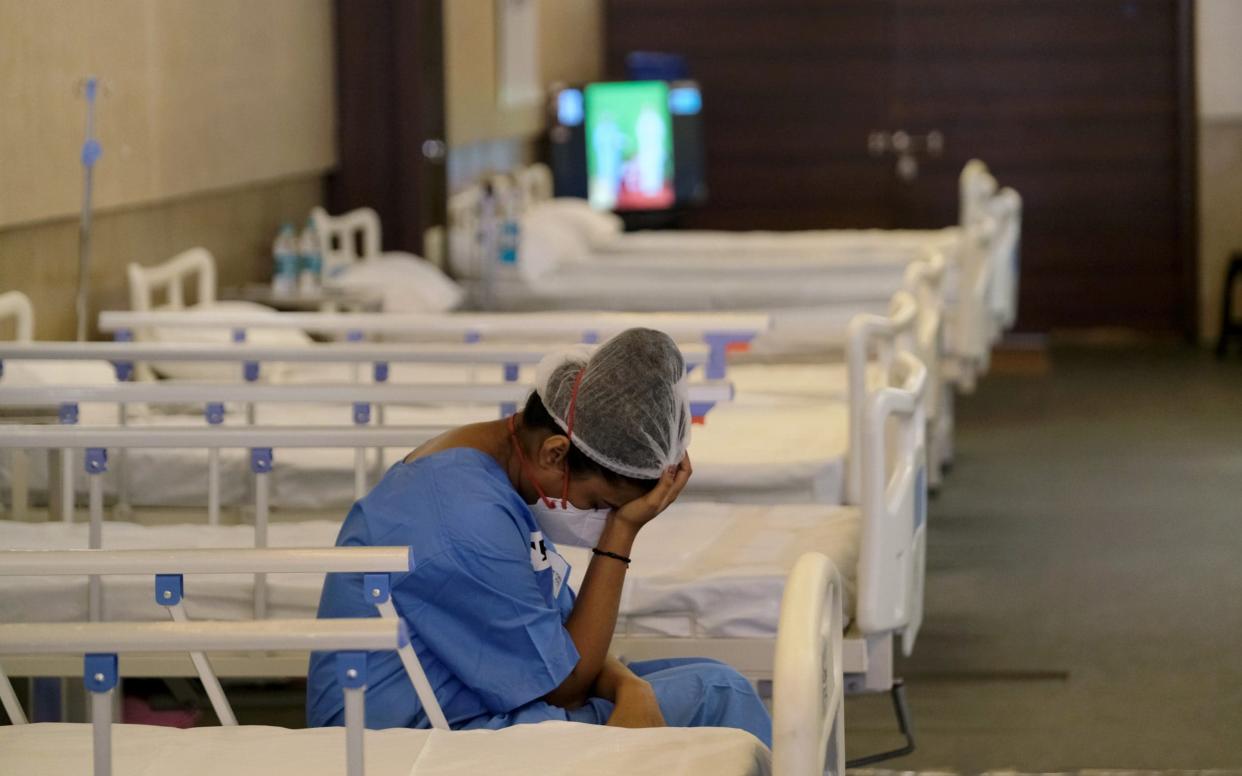 A nurse rests in a makeshift ward at an emergency Covid-19 care center  -  T. Narayan/Bloomberg