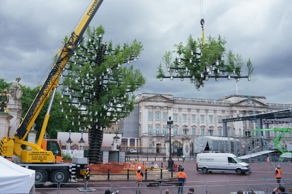 LONDON, ENGLAND - MAY 24: A team of workers add the final parts to the Queen's Green Canopy ahead of the Platinum Jubilee on May 24, 2022 in London, England. The sculpture, which will stand outside Buckingham Palace for the duration of the Queen's Platinum Jubilee celebrations in June, was created by British designer Thomas Heatherwick's studio, Heatherwick Studio. It consists of 350 native British trees planted in aluminium pots, which will be donated to community groups after the Jubilee celebrations.  (Photo by Dominic Lipinski - WPA Pool/Getty Images)