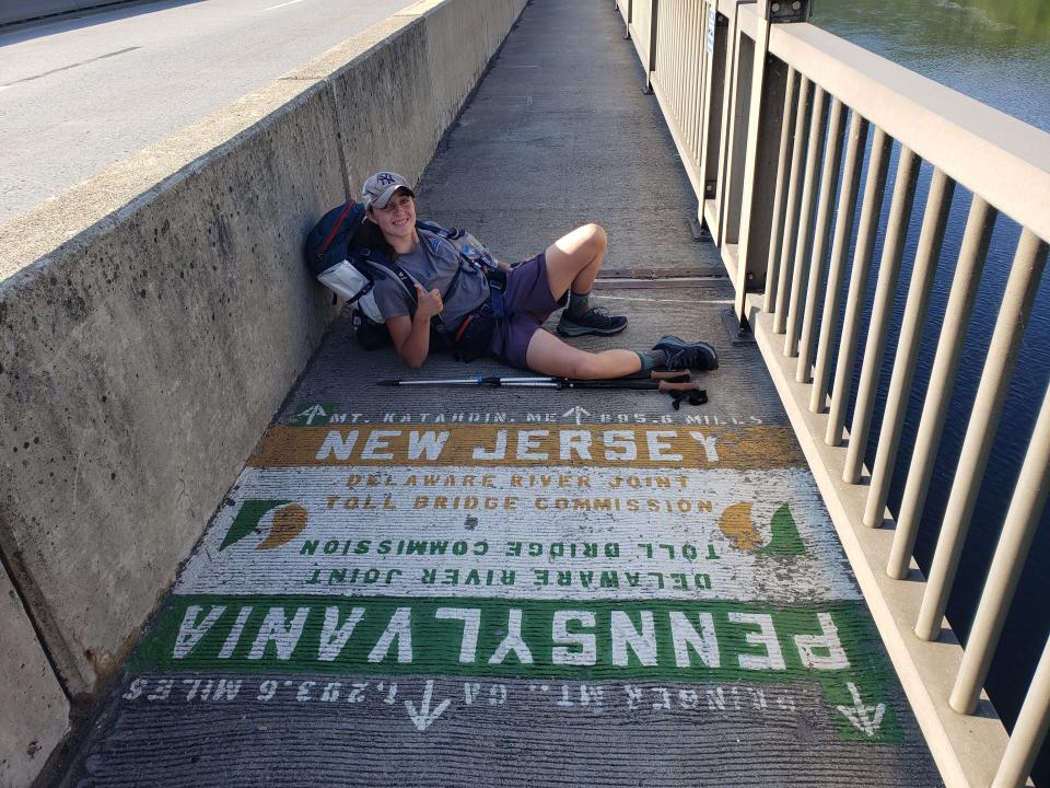 Kendall Gemellaro crosses from Pennsylvania into New Jersey on the Appalachian Trail along the Interstate 80 bridge walkway.