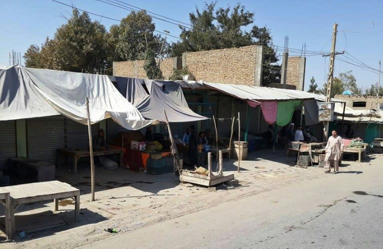 Afghan vendors at roadside shops in Kunduz on October 4, 2015, as Afghan forces, backed up by their NATO allies, claim to have wrested back control of the city