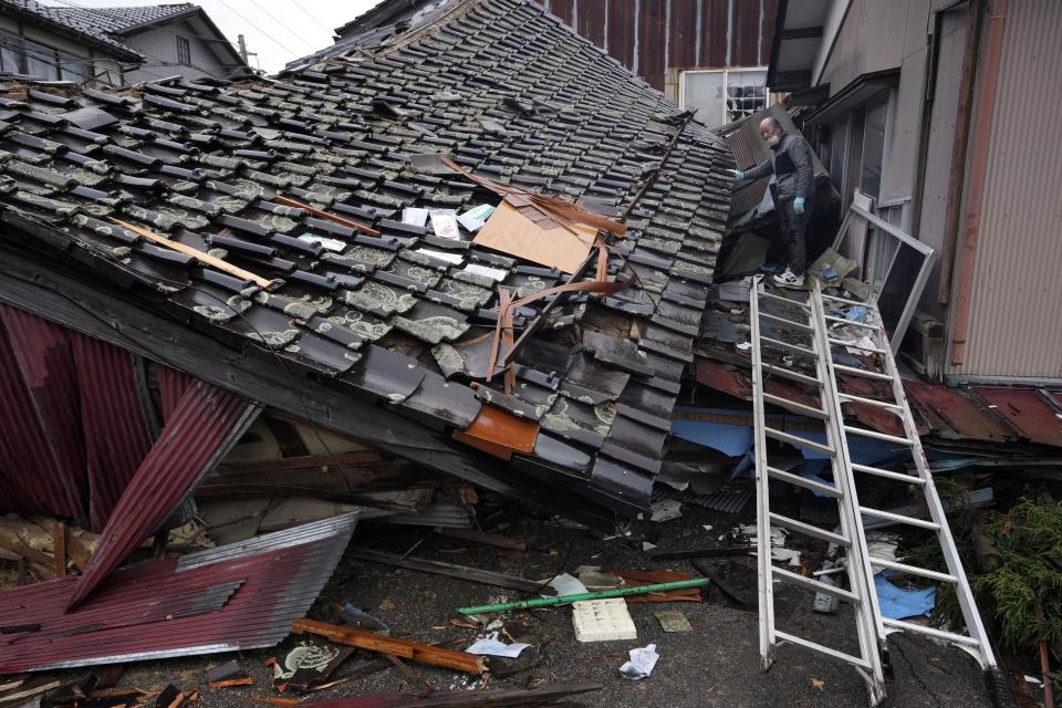 A man searches a collapsed house caused by powerful earthquake in Suzu, Ishikawa Prefecture Wednesday, Jan. 3, 2024. A series of powerful earthquakes hit western Japan, damaging buildings, vehicles and boats, with officials warning people in some areas on Tuesday to stay away from their homes because of a risk of more strong quakes. (AP Photo/Hiro Komae)