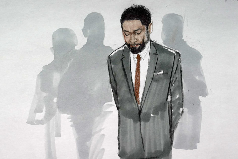 In this courtroom sketch, actor Jussie Smollett stands with his legal team in a Leighton Criminal Courthouse courtroom, Thursday, Dec. 9, 2021, in Chicago, after a jury found him guilty on five of six charges he staged a racist, anti-gay attack on himself and lied to police about it. (AP Photo/Cheryl Cook)