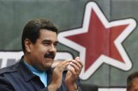 Venezuelan President Nicolas Maduro applauds during a ceremony commemorating the second anniversary of former president Hugo Chavez's death, in Caracas on March 5, 2015