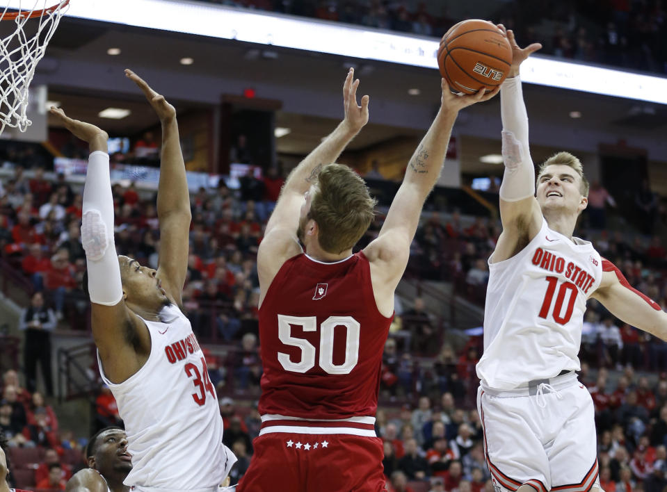 Indiana's Joey Brunk, center, tries to shoot between Ohio State's Kaleb Wesson, left, and Justin Ahrens during the first half of an NCAA college basketball game Saturday, Feb. 1, 2020, in Columbus, Ohio. (AP Photo/Jay LaPrete)