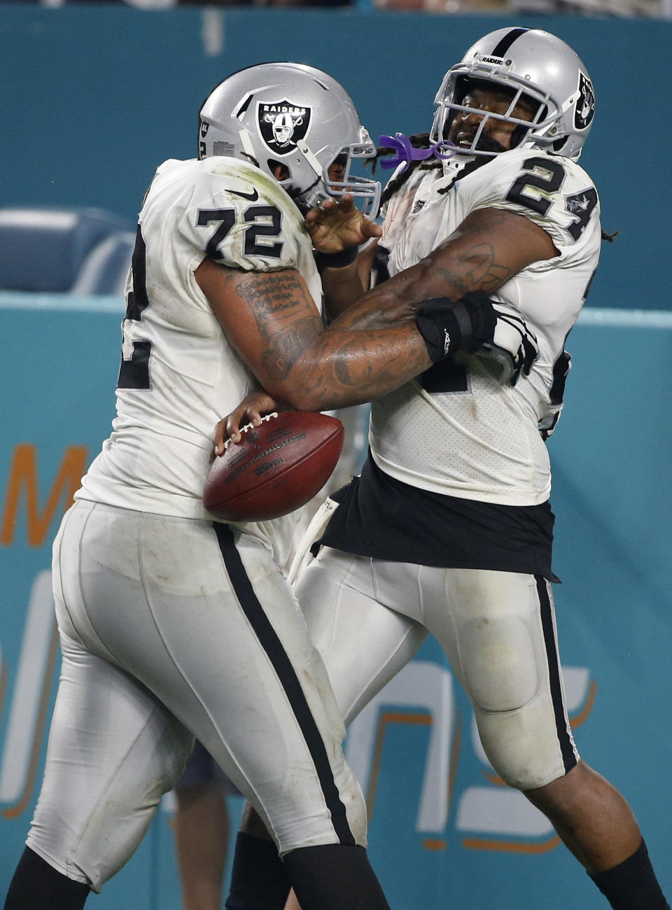 <p>Oakland Raiders offensive tackle Donald Penn (72) lifts running back Marshawn Lynch (24) after Lynch scored a touchdown, during the second half of an NFL football game against the Miami Dolphins, Sunday, Nov. 5, 2017, in Miami Gardens, Fla. (AP Photo/Wilfredo Lee) </p>