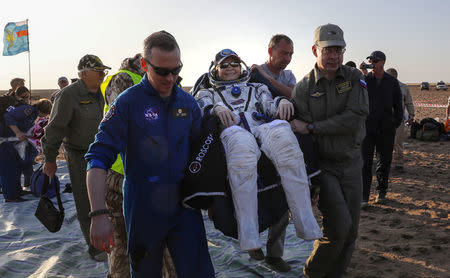 Ground personnel carry member of the International Space Station (ISS) crew Peggy Annette Whitson of the U.S. after the landing of the Soyuz MS-04 capsule in a remote area outside the town of Dzhezkazgan (Zhezkazgan), Kazakhstan September 3, 2017. REUTERS/Sergei Ilnitsky/Pool