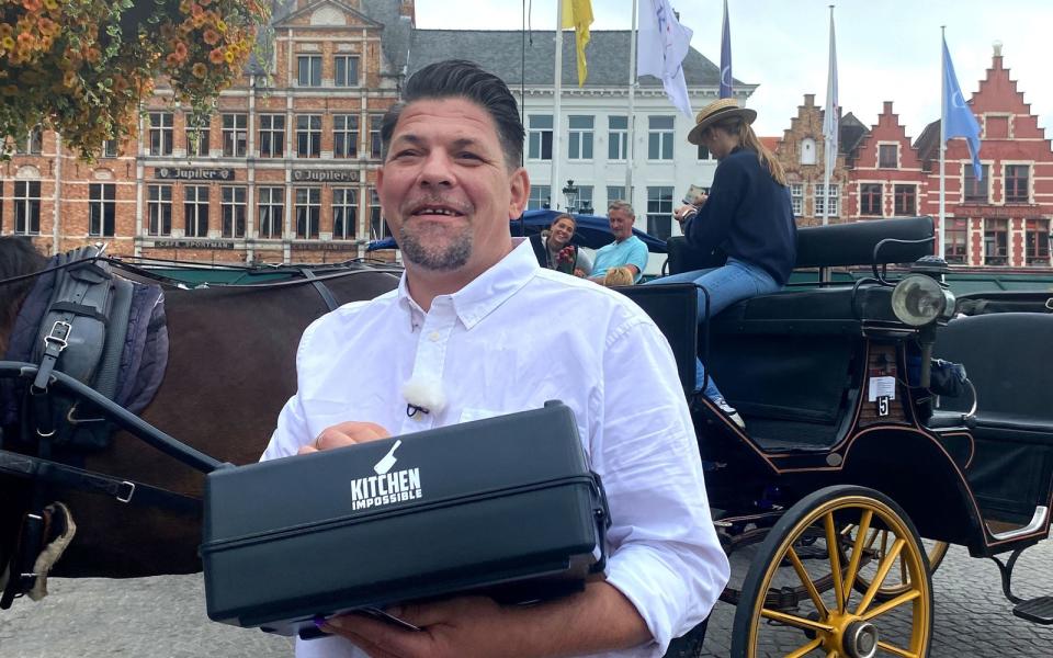 In Brügge (Belgien) bekommt Tim Mälzer von Anton Schmaus Holzblumen, dann Pralinen zum Nachkochen. Noch lächelt Mälzer, flucht aber innerlich. 