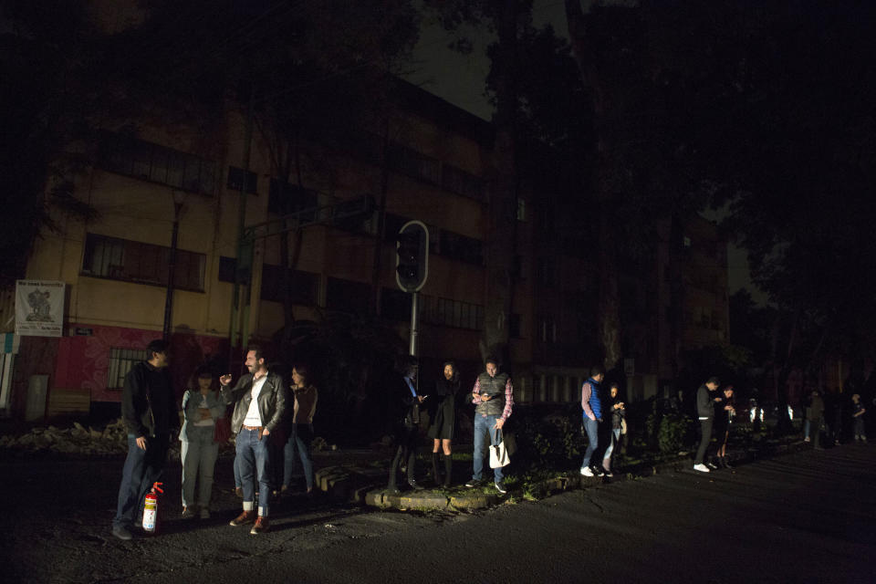 <p>People who evacuated from bars during an earthquake stand in the street in La Roma neighborhood of Mexico City, sections of which lost power, just before midnight on Thursday, Sept. 7, 2017. (AP Photo/Rebecca Blackwell) </p>