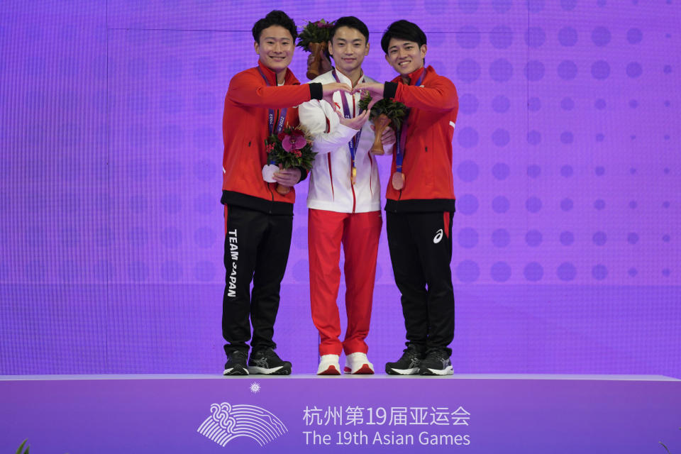 Gold medalist China's Jingyuan Zou, center, silver medalist Japan's Takeru Kitazono, left, and bronze medalist Japan's Kakeru Tanigawa pose on the podium during the awards ceremony of the Artistic Gymnastics men's parallel bars at 19th Asian Games in Hangzhou, China, Friday, Sept. 29, 2023. (AP Photo/Aijaz Rahi)