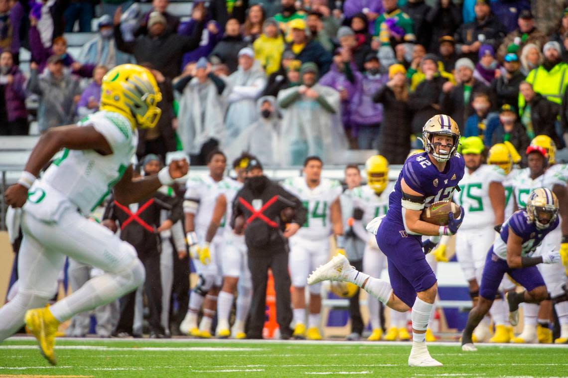 Washington linebacker Carson Bruener (42) runs back an interception as Oregon quarterback Anthony Brown (13) chases him down during the first quarter of a Pac-12 game on Saturday at Husky Stadium in Seattle.