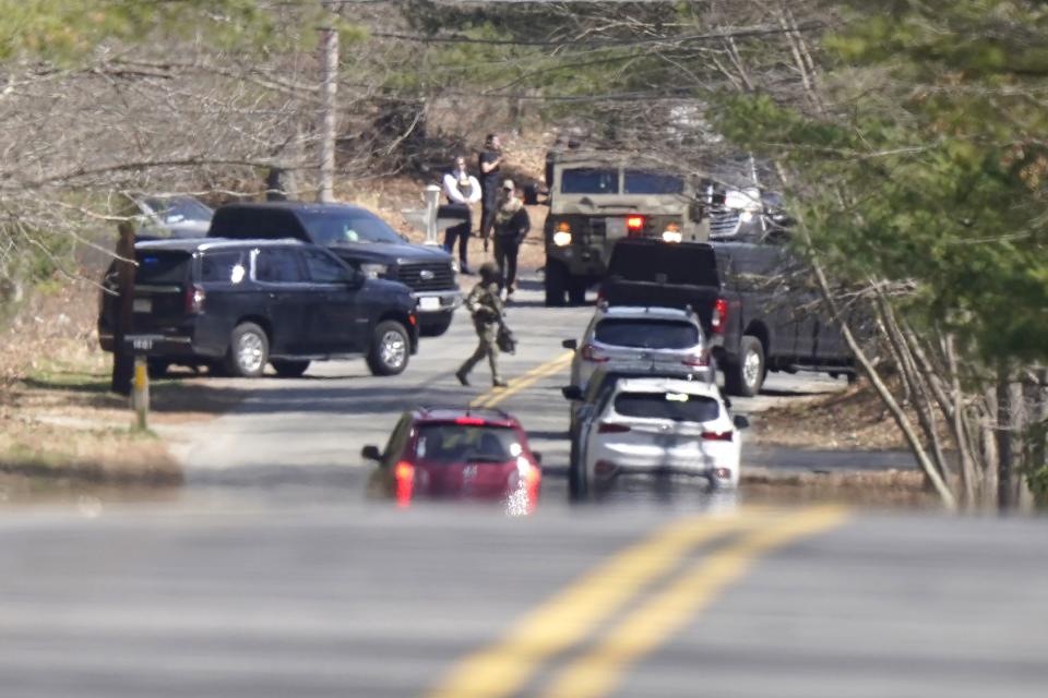 Members of law enforcement assemble on a road, Thursday, April 13, 2023, in Dighton, Mass., near where FBI agents converged on the home of a Massachusetts Air National Guard member who has emerged as a main person of interest in the disclosure of highly classified military documents on the Ukraine. The guardsman was identified as 21-year-old Jack Teixeira. (AP Photo/Steven Senne)